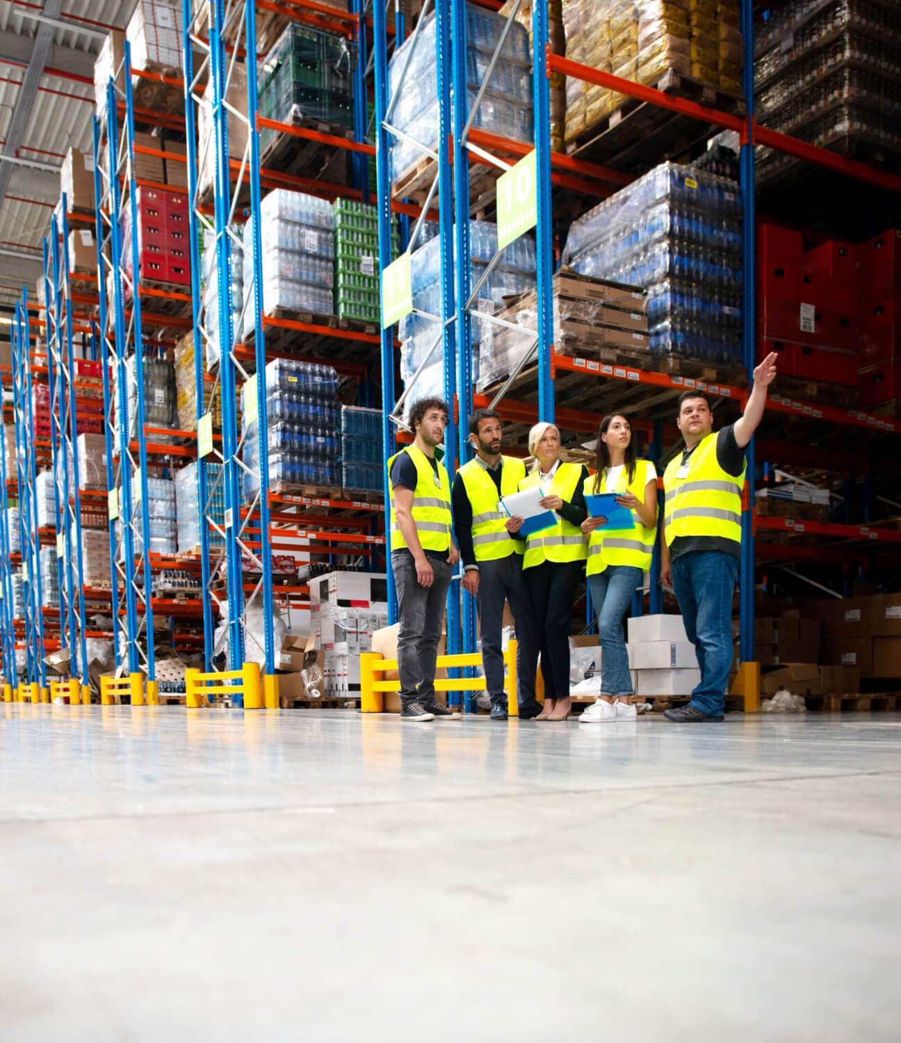 Shelving Shop Consultants showing plans to warehouse managers in a warehouse full of racking.