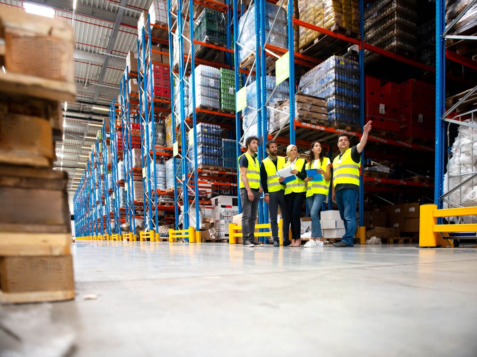 Shelving Shop Consultants showing plans to warehouse managers in a warehouse full of racking.